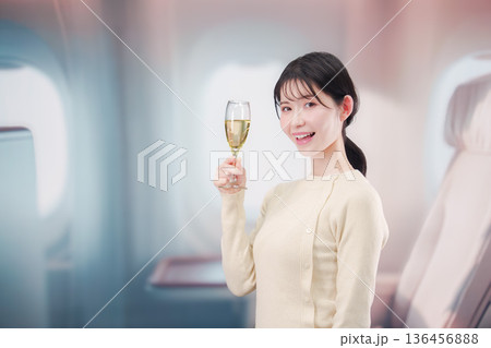 飛行機のビジネスクラスでワインを飲む女性 136456888