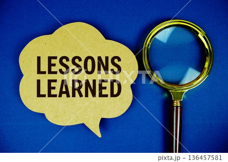 Lessons Learned text on speech bubble with magnifying glass on navy blue background Lessons Learned text on speech bubble with magnifying glass on navy blue background 136457581