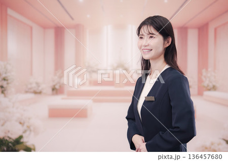 葬儀会社で接客をする若い女性スタッフ 葬儀会社で接客をする若い女性スタッフ 136457680