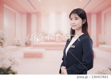 葬儀会社で接客をする若い女性スタッフ 葬儀会社で接客をする若い女性スタッフ 136457681
