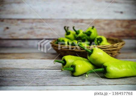 Fresh raw green bell pepper in bamboo basket on wooden background Fresh raw green bell pepper in bamboo basket on wooden background 136457768