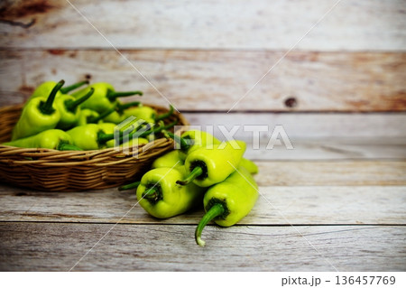 Fresh raw green bell pepper in bamboo basket on wooden background Fresh raw green bell pepper in bamboo basket on wooden background 136457769
