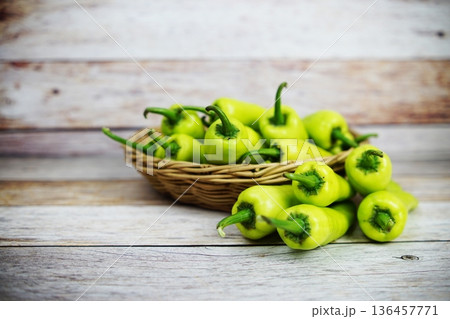 Fresh raw green bell pepper in bamboo basket on wooden background 136457771