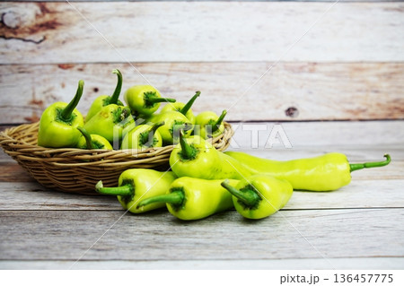 Fresh raw green bell pepper in bamboo basket on wooden background Fresh raw green bell pepper in bamboo basket on wooden background 136457775
