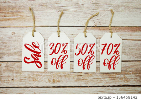 Price tag with "Sale 30%, 50% 70% off" is placed on wooden background Price tag with "Sale 30%, 50% 70% off" is placed on wooden background 136458142