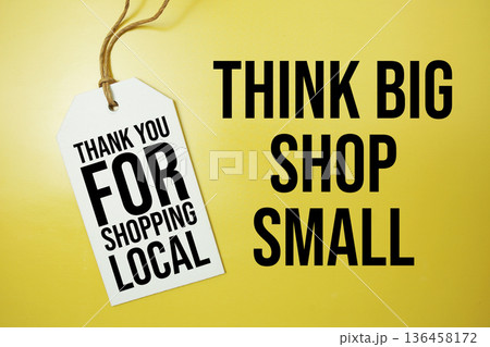 Think Big Shop Small text message on price tag top view on yellow background, business and promotion concept Think Big Shop Small text message on price tag top view on yellow background, business and promotion concept 136458172