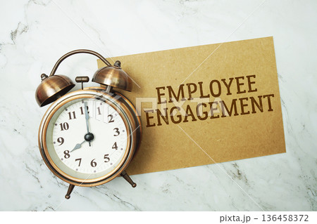 Employee Engagement text written on paper card with alarm clock on marble background 136458372