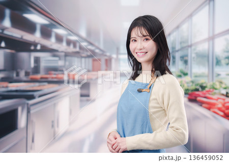 大きなキッチンで働く若い女性 大きなキッチンで働く若い女性 136459052