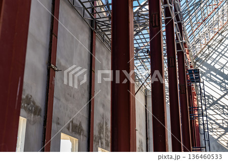 Uprisen angle photo shot of the huge steel roof frame structure detail under construction at the work site. Uprisen angle photo shot of the huge steel roof frame structure detail under construction at the work site. 136460533