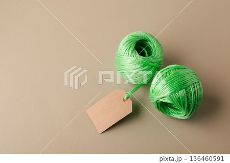 Two green spools of recycled polyester fiber with blank label indicating the product's eco-friendliness. Recycling, conscious waste management Two green spools of recycled polyester fiber with blank label indicating the product's eco-friendliness. Recycling, conscious waste management 136460591