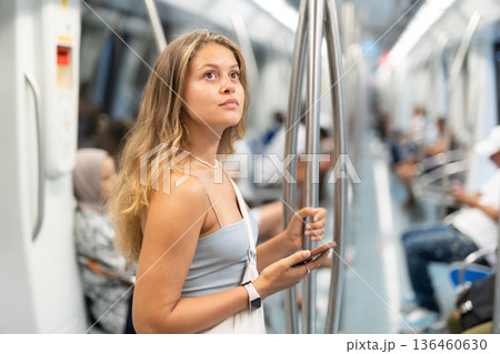 Young girl standing in wagon holding phone in hand 136460630