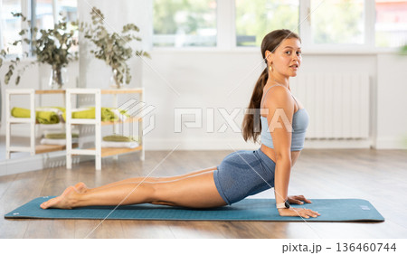 Young woman practicing yoga in bhujangasana pose 136460744