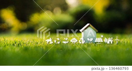 Eco-friendly house model on green grass with sustainability icons. Eco-friendly house model on green grass with sustainability icons. 136460793