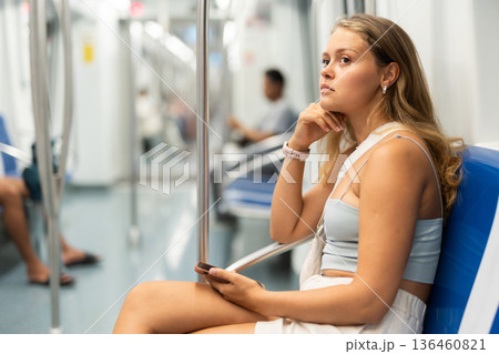 Young girl sitting in wagon holding mobile phone in hand Young girl sitting in wagon holding mobile phone in hand 136460821
