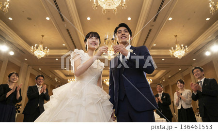 シャンパングラスを高く掲げて乾杯する笑顔の日本人新郎新婦のローアングル シャンパングラスを高く掲げて乾杯する笑顔の日本人新郎新婦のローアングル 136461553