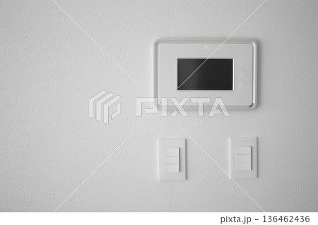 It's a white wall with an intercom and a switch. 136462436