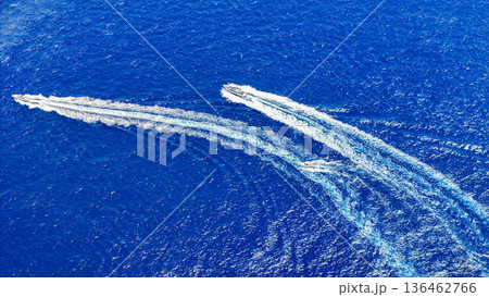 Thrilling boat race across the vibrant blue ocean waves on a sunny day 136462766