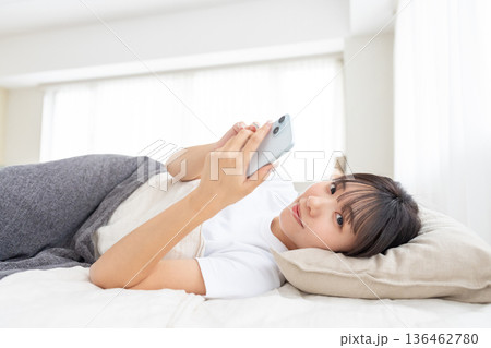 ベッドでスマホを操作する若い女性 ベッドでスマホを操作する若い女性 136462780