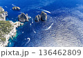 Breathtaking view of azure waters and rocky formations near a coastal paradise filled with boats sailing beneath a clear sky 136462809