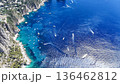Vibrant blue waters of Capri invite exploration by boats under the sun in a stunning coastal landscape 136462812