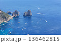 Lush coastal panorama featuring dazzling blue waters and boats near dramatic rocky formations in Mediterranean paradise 136462815