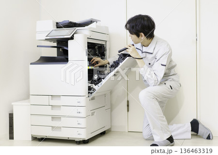 コピー機のメンテナンスをする若い日本人男性 コピー機のメンテナンスをする若い日本人男性 136463319