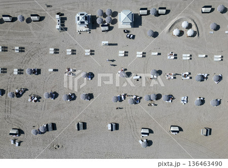 Beach vacation at sea in summer. Sea relax under beach umbrella. Travel to sea. Aerial top view of sand beach with sunbed and umbrella. People on beach coastline enjoying sun. Summer vacation Beach vacation at sea in summer. Sea relax under beach umbrella. Travel to sea. Aerial top view of sand beach with sunbed and umbrella. People on beach coastline enjoying sun. Summer vacation 136463490