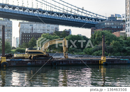 Brooklyn bridge repair with heavy machinery excavator. Construction site and industrial heavy machine excavator. Bridge repair. Excavator digger. Heavy equipment machinery 136463508