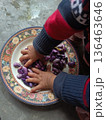 Toddler playing with colorful purple Scarlet Runner beans on a floral plate for sensory development 136463646