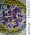 Top view of raw purple and white speckled runner beans in a rustic woven basket 136463655