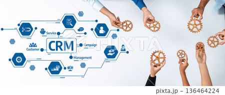 Collaborative Hands Holding Gears with CRM Concept on Table Representing Customer Relationship Management Strategy and Business Process Improvement. Amity 136464224