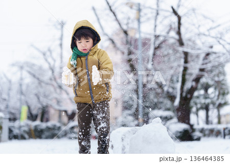 雪の公園で遊ぶ6歳の男の子 雪の公園で遊ぶ6歳の男の子 136464385