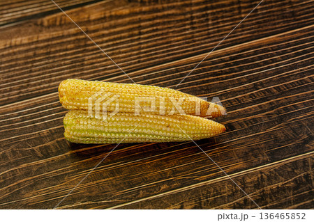 Pile of fresh raw baby corn on a textured background Pile of fresh raw baby corn on a textured background 136465852