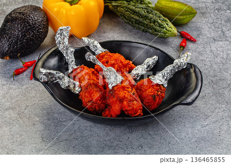 Spicy Indian Chicken Lollipops appetizer in a bowl with fresh vegetables Spicy Indian Chicken Lollipops appetizer in a bowl with fresh vegetables 136465855