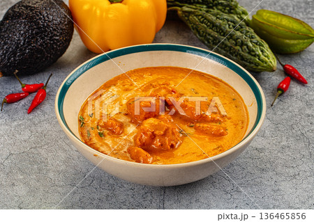 Spicy Indian chicken curry in a bowl with fresh vegetables and chili peppers. Spicy Indian chicken curry in a bowl with fresh vegetables and chili peppers. 136465856