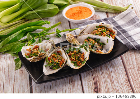 Gournet grilled oysters with onion and peanut 136465896