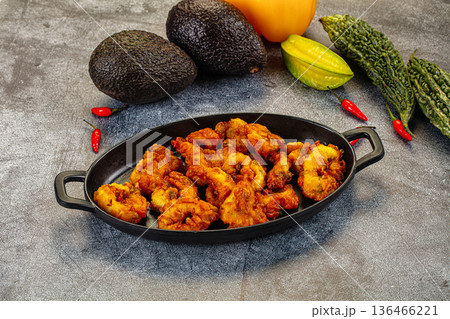 Crispy fried calamari rings appetizer on a plate with fresh chili and avocado. 136466221