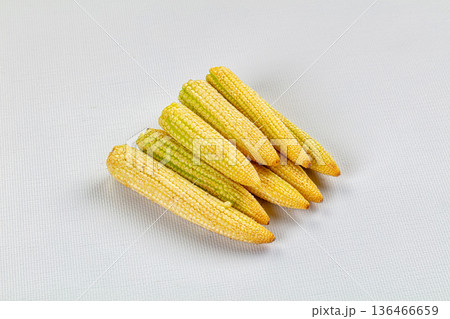 Pile of fresh raw baby corn on a textured background 136466659