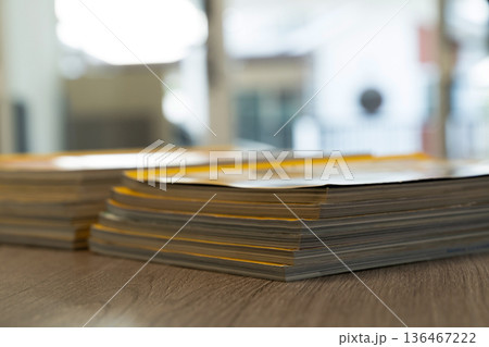 Paperwork backlog stacked pile of file folders and reports on office, representing records management, audit preparation, compliance review and organization. 136467222