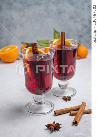 Two glasses of mulled wine, orange, cinnamon, and star anise on a light background Two glasses of mulled wine, orange, cinnamon, and star anise on a light background 136467382