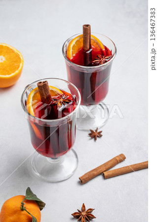 Two glasses of mulled wine, orange, cinnamon, and star anise on a light background 136467383