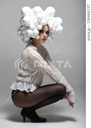 Woman posing with avant-garde white spheres hairstyle 136468157