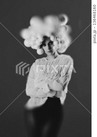 Woman experiencing surreal thoughts with floating spheres 136468160