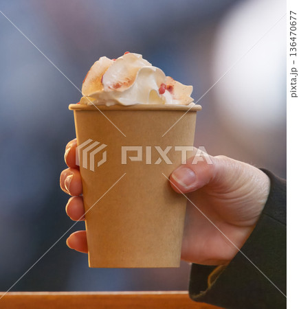 Hand Holding Paper Cup With Whipped Cream Topping, Cozy Coffee Moment in Winter 136470677