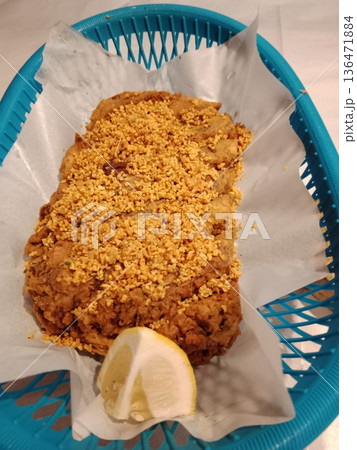 Crispy fried patty topped with crunchy fried onions in basket with lemon. Crispy fried patty topped with crunchy fried onions in basket with lemon. 136471884
