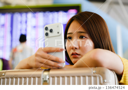 空港でスマホ確認する女性 ■撮影協力：関西国際空港（KIX） 136474524