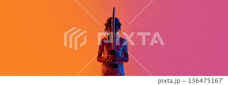 Cricket batsman standing front view with bat upright in neon studio. Banner Cricket batsman standing front view with bat upright in neon studio. Banner 136475167
