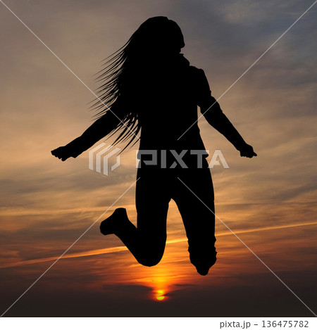 Girl silhouette jumping in the air, sunset sky Girl silhouette jumping in the air, sunset sky 136475782