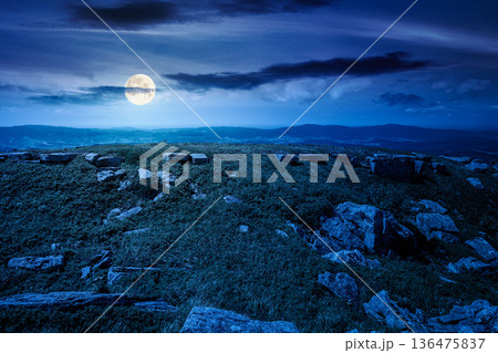 grassy alpine meadow in carpathian mountain landscape at night. sharp rocks and huge boulders among lush grass on rolling hills in full moon light. open space scenery for wanderlust and exploration grassy alpine meadow in carpathian mountain landscape at night. sharp rocks and huge boulders among lush grass on rolling hills in full moon light. open space scenery for wanderlust and exploration 136475837