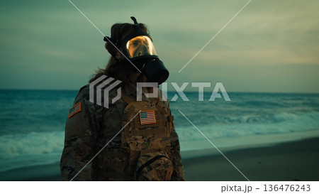Soldier in toxic environment salutes at Memorial Day celebration near ocean Soldier in toxic environment salutes at Memorial Day celebration near ocean 136476243